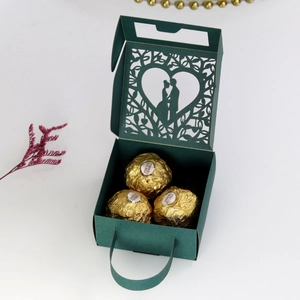 Detail of dark green laser-cut gift box featuring couple silhouette and handle