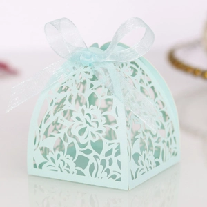 Intricate laser-cut mint green wedding favor box with delicate floral patterns and ribbon