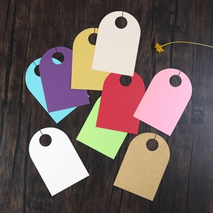 Close-up of multicolored wedding wine glass tags on dark wood texture with dried flowers