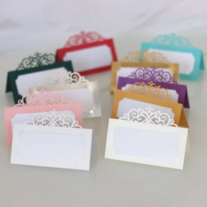 Stack of laser cut European table place cards in various pearlescent paper colors