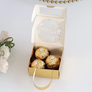Detail of laser-cut golden birthday gift box with hollow Happy Birthday text and chocolates