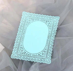 Dettaglio di un biglietto in pizzo azzurro tagliato al laser con motivi floreali eleganti