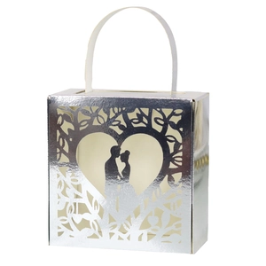Close-up of laser-cut silver wedding candy box with heart-shaped couple silhouette