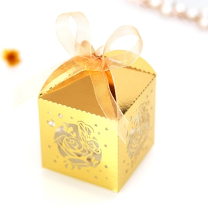 Detail showing laser-cut rose and butterfly patterns on golden wedding favor box