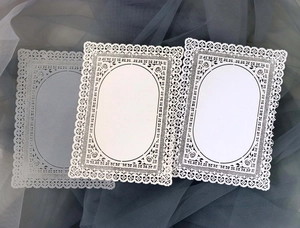 Dettaglio di carte in pizzo tagliate al laser con motivi floreali vintage per scrapbooking