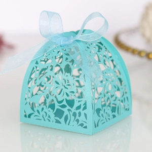 Detail of light blue laser-cut candy box with floral patterns and a matching ribbon bow