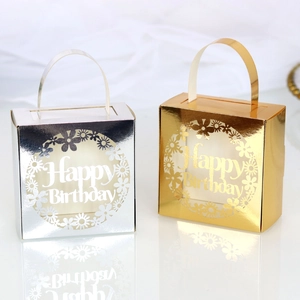 Detail of gold and silver laser-cut Happy Birthday candy boxes with flower patterns