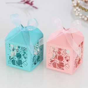 Detail of laser-cut floral candy box with elegant ribbon bow for party favors