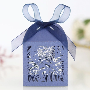 Detailed laser-cut dark blue favor box with leaf patterns and organza ribbon bow