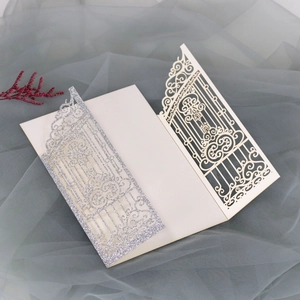 Detailed view of silver glitter laser-cut invitation card on elegant mesh background