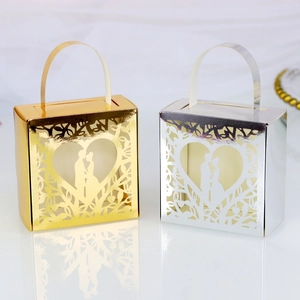 Macro detail of laser-cut heart favor boxes in metallic gold and silver finish