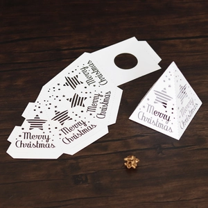 DIY white paper pyramid gift boxes with Merry Christmas star patterns on a wood background