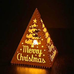 Macro shot of pyramid Christmas light with warm LED glow and Merry Christmas cutout