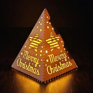 Macro detail of pyramid star night light with Merry Christmas hollow carvings and warm glow