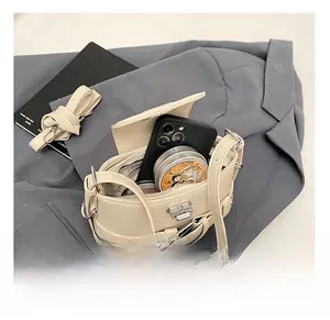 Détail de l'intérieur du sac seau crème montrant la capacité pour téléphone et maquillage