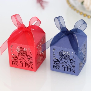 Detail of laser-cut tropical leaf patterns and ribbon bows on luxury gift boxes