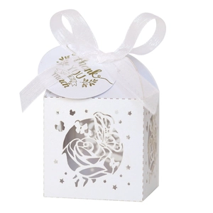 Intricate laser-cut white wedding favor box with rose patterns and thank you ribbon