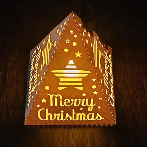 Detail of Christmas hollow-out pyramid paper lamp box with warm LED lighting and star motifs