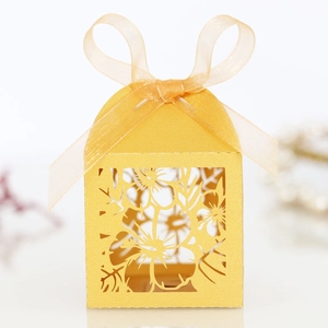 Detail of laser-cut flower pattern on yellow pearlescent cardstock gift box with ribbon
