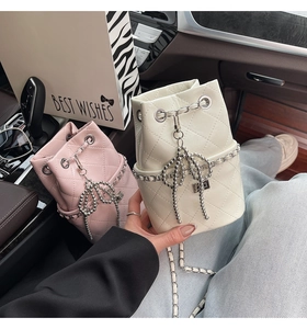 Detail der gesteppten Beuteltasche mit Kettenzug und perlenbesetztem Schleifenanhänger