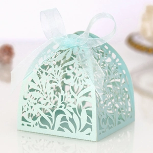 Detail of laser-cut floral patterns and sheer ribbon bow on light blue wedding favor box