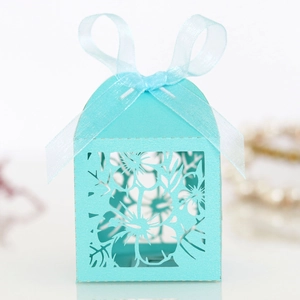 Close-up of laser-cut hollow floral pattern on light blue pearlescent favor box