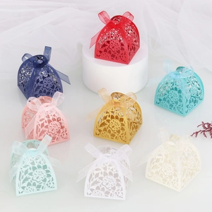 Laser cut hollow flower candy boxes in multiple colors with ribbons and handles