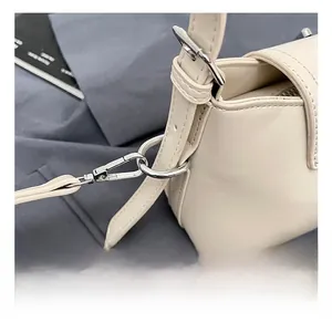 Détail du crochet en métal argenté et de la couture sur le sac seau en cuir beige