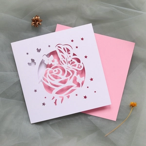 Détail de la rose et du papillon découpés au laser sur une carte en papier blanc