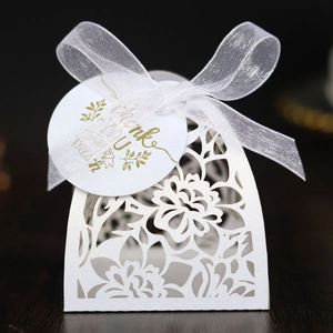 Detail of laser-cut flower candy box with white organza ribbon and Thank You tag