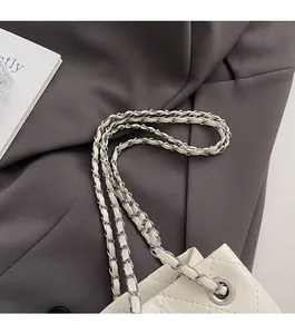Detail der beige gesteppten Lederschultertasche mit durchflochtener silberner Metallkette