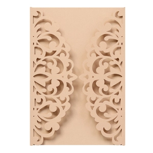 Macro detail of laser-cut floral scroll patterns on brown pearlescent paper invitation