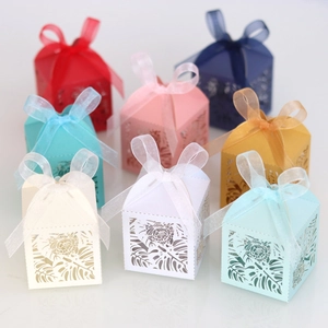 Close-up of laser-cut hollow leaf patterns and ribbon bows on multi-colored candy boxes