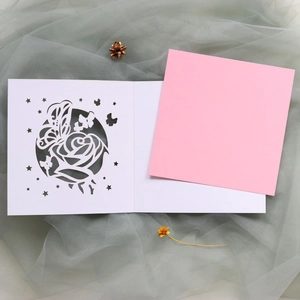 Détail du faire-part de mariage découpé au laser avec rose, papillon et carte rose