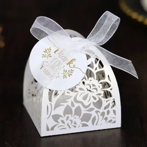 Laser cut white wedding favor box with floral patterns and a Thank You gift tag