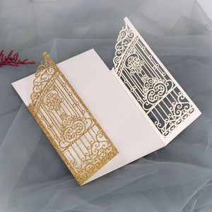 Detail view of laser-cut gatefold wedding invitation with gold glitter and cream lace pattern