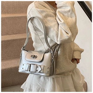 Sac à bandoulière argenté avec boucle métallique et fermoir rotatif sur modèle