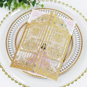 Detail of laser-cut gold glitter wedding invitation with floral inner card and elegant text