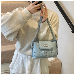 Détail du sac seau bleu clair avec lanières à œillets décoratives et boucle en métal