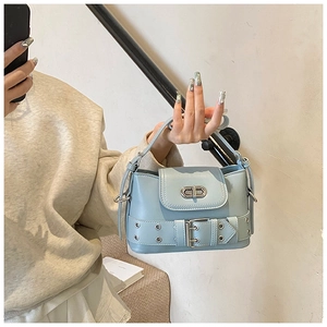 Détail du sac seau bleu clair avec boucle métallique CD et œillets argentés décoratifs