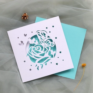 Détail de carte de vœux découpée au laser avec motif papillon et rose et enveloppe