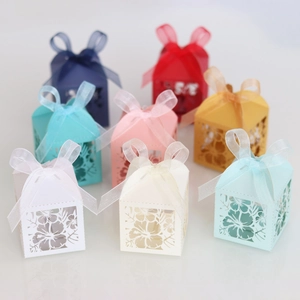 Detail of laser-cut floral candy boxes in various colors with elegant ribbon bows