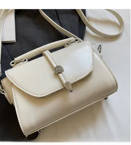 Detail view of cream white PU leather square handbag with round silver metal twist lock