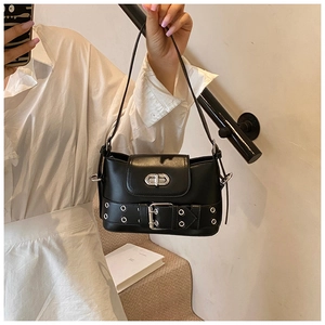 Détail du sac seau en similicuir noir avec œillets métalliques et fermoir rotatif