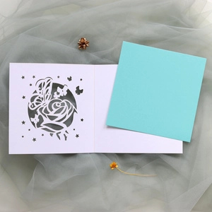 Détail de la carte de mariage découpée au laser avec roses et papillons délicats