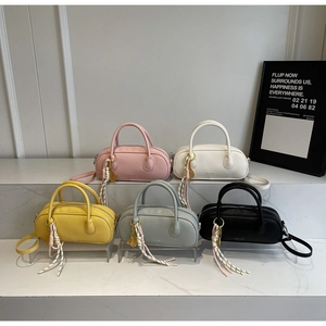 Litchi pattern Boston bags in five colors displayed on marble tiers with elegant charms
