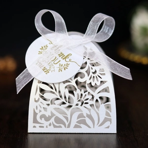 Detail of white laser-cut hollow gift box with floral pattern and Thank You tag