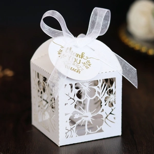Detailed white laser-cut party favor box with floral patterns and thank you tag