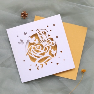 Détail de l'invitation de mariage découpée au laser avec motifs papillon et rose sur doré