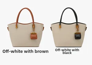Detail of canvas tote bags in beige with contrast brown and black PU leather straps